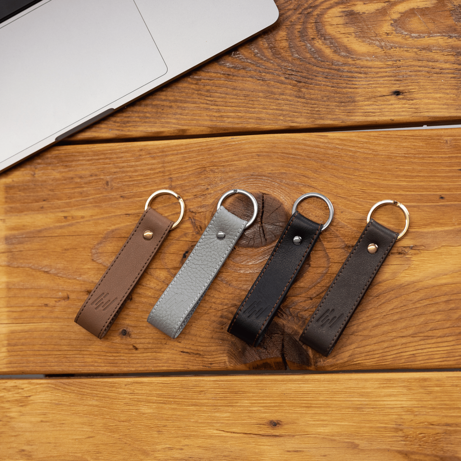 TiCad Accesoire Schlüsselanhänger Classic aus Leder liegt auf Holzboden